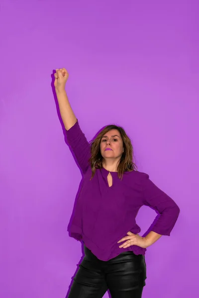 empowered woman with fist up on a purple background to celebrate women\'s day