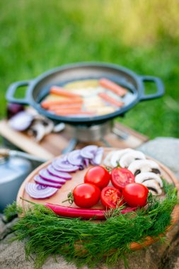 Kızartma tavasında yemek pişirmek, açık havada ateşin yanında..
