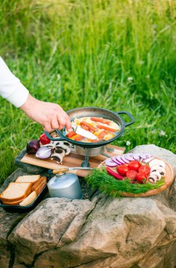 Kızartma tavasında yemek pişirmek, açık havada ateşin yanında..