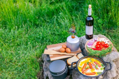 Kızartma tavasında yemek pişirmek, açık havada ateşin yanında..