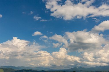Dağların en güzel manzarası, güneşli bir günde bulutlu gökyüzü..
