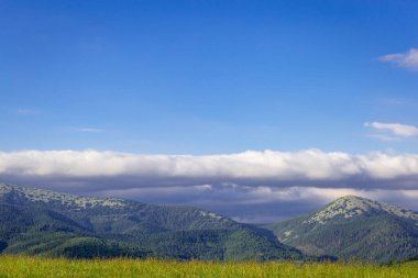 Dağların en güzel manzarası, güneşli bir günde bulutlu gökyüzü..