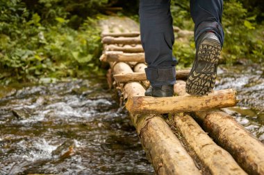 Sırt çantası ve yürüyüş direkleri ile dağlık arazide yürüyüş yapmak.