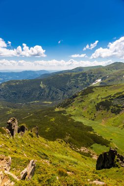 Arka planda zirveleri, güneşli bir günde bulutları olan en güzel manzara..