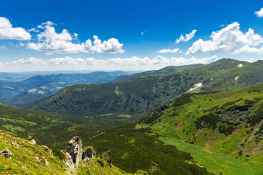 Arka planda zirveleri, güneşli bir günde bulutları olan en güzel manzara..