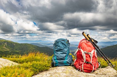 Zirveli ve sırt çantalı dağ manzarası.