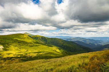 Manzara, zirveleri ve güzel gökyüzü olan yüksek dağlardır..