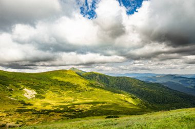 Manzara, zirveleri ve güzel gökyüzü olan yüksek dağlardır..