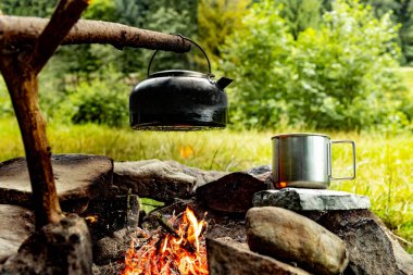 Dağlarda yürüyüş yaparken kamp ateşinde kahve demliği..