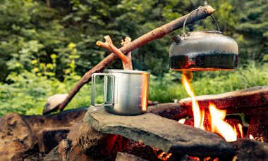 Dağlarda yürüyüş yaparken kamp ateşinde kahve demliği..