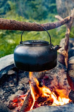 Dağlarda yürüyüş yaparken kamp ateşinde kahve demliği..