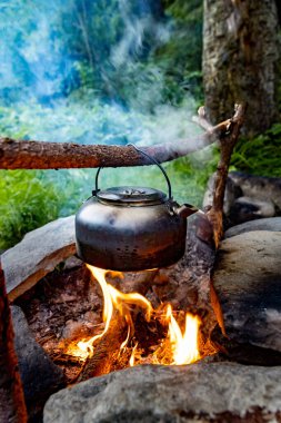Dağlarda yürüyüş yaparken kamp ateşinde kahve demliği..