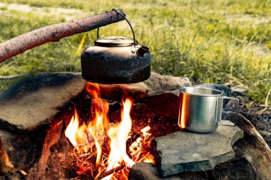 Dağlarda yürüyüş yaparken kamp ateşinde kahve demliği..