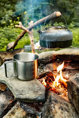 Dağlarda yürüyüş yaparken kamp ateşinde kahve demliği..