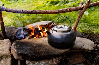 Dağlarda yürüyüş yaparken kamp ateşinde kahve demliği..