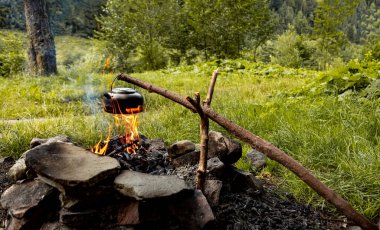 Ormanda açık ateşin üzerinde çay yapmak. Tencere dibin kara seninki benden kara..