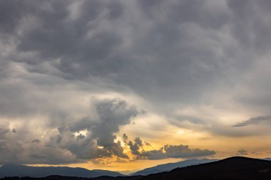 Arka planda zirveleri, gün batımında bulutları olan en güzel manzara..