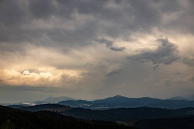 Arka planda zirveleri, gün batımında bulutları olan en güzel manzara..