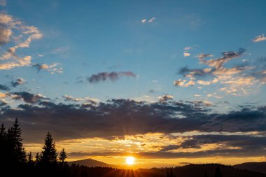 Arka planda zirveleri, gün batımında bulutları olan en güzel manzara..
