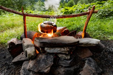 Dağlarda yürüyüş yaparken kamp ateşinde kahve demliği..
