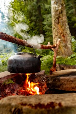 Dağlarda yürüyüş yaparken kamp ateşinde kahve demliği..