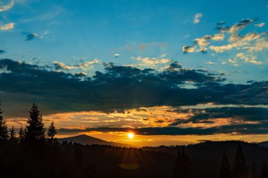 Arka planda zirveleri, gün batımında bulutları olan en güzel manzara..