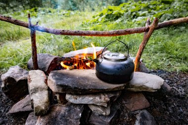 Dağlarda yürüyüş yaparken kamp ateşinde kahve demliği..
