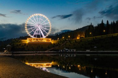 Dönme dolap ve gece aydınlatma. Bukovel 'de gece manzarası cazibesi.