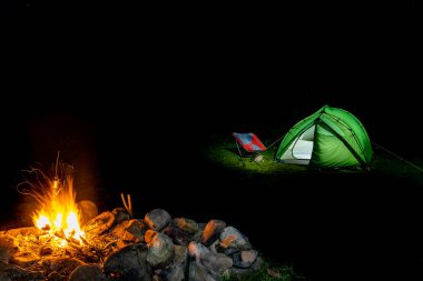 Gece bir çadırla ateşin yanında kamp yapmak..
