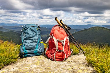 Zirveli ve sırt çantalı dağ manzarası.