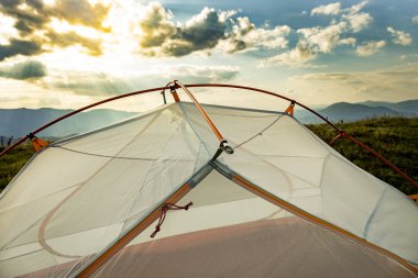 Yazın dağlarda sarı bir çadırla yürüyüş yapmak..