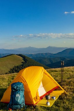 Yazın bir sırt çantası ve çadırla dağlarda yürüyüş yapmak. Dağların güzel manzarası.