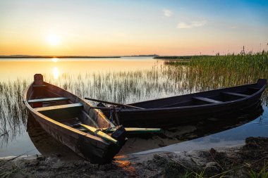 Göl kıyısında kürekleri olan geleneksel ahşap balıkçı teknesi..