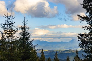 Dağların en güzel manzarası, güneşli bir günde bulutlu gökyüzü..