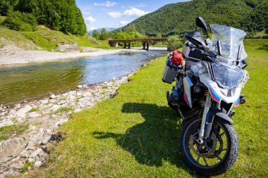 Dağlarda motosiklet gezisi, dağ nehri kıyısında güzel bir manzara..