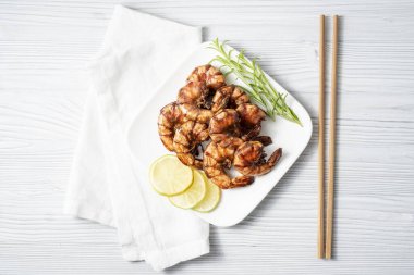 Tahta bir masada sebzeli ızgara kızarmış karides.