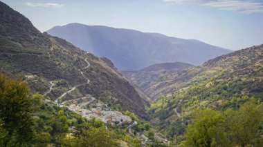 Granada 'nın Alpujarras bölgesindeki bir vadinin panoramik manzarası. Arkasında beyaz bir köy var.