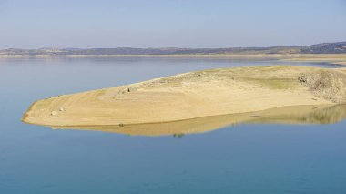 reflections in the water of the Valdecaas reservoir in Extremadura clipart