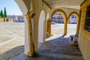 Stone arches with whitewashed walls in the main square of the Cceres town of Garrovillas de Alconetar clipart