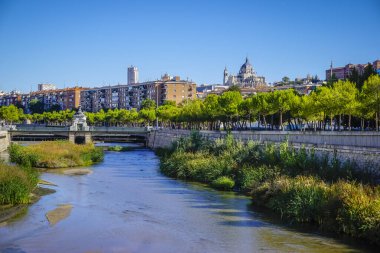 Madrid 'deki Arganzuela Köprüsü, nehir köprüsünü sarmal bir yapı ve yayalar ve bisikletçiler için tahta şeritler ile vuruyor.