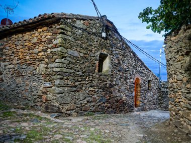 Imagen nocturna de la calle de una aldea con paredes fabricadas con piedra y adobe