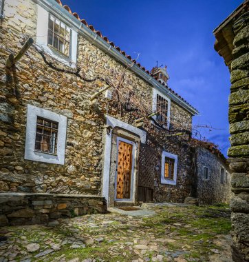 Imagen nocturna de la calle de una aldea con paredes fabricadas con piedra y adobe