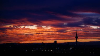 Gün batımında Madrid 'in ufuk çizgisinin panoramik görüntüsü kırmızımsı tonlar ve piruli profiliyle