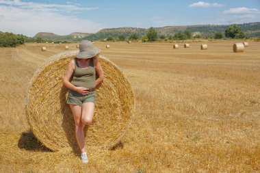 Pipet balyaların yanındaki şapkalı kadın.