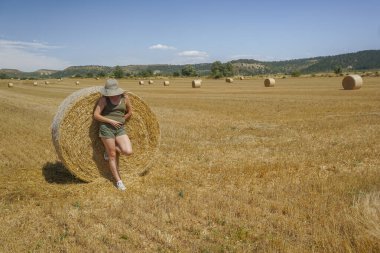 Pipet balyaların yanındaki şapkalı kadın.