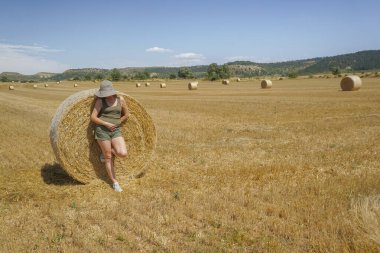 Pipet balyaların yanındaki şapkalı kadın.