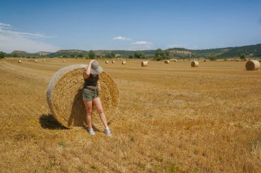 Pipet balyaların yanındaki şapkalı kadın.