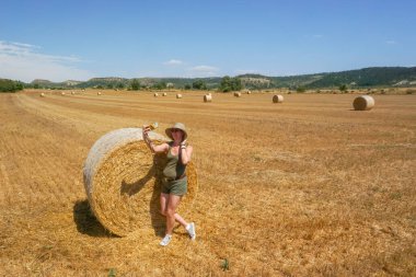 Pipet balyaların yanındaki şapkalı kadın.