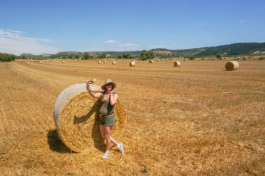 Pipet balyaların yanındaki şapkalı kadın.