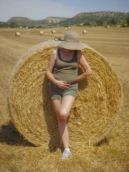 Pipet balyaların yanındaki şapkalı kadın.